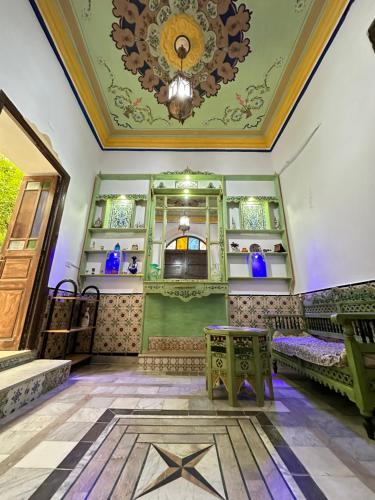 a room with green walls and a ceiling with a chandelier at Dar El Rezk in Tunis
