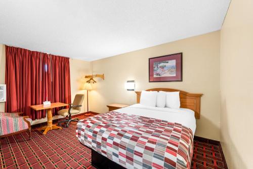 a hotel room with a bed and a desk at Americas Best Value Inn Decatur in Decatur