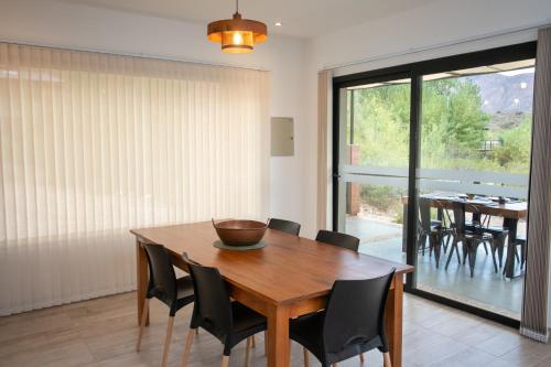 a dining room with a wooden table and chairs at Viví Potrerillos in Potrerillos