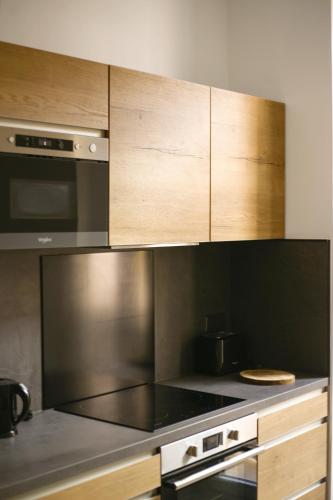 une cuisine avec des appareils en acier inoxydable et des armoires en bois dans l'établissement Bon'appart, à Ajaccio