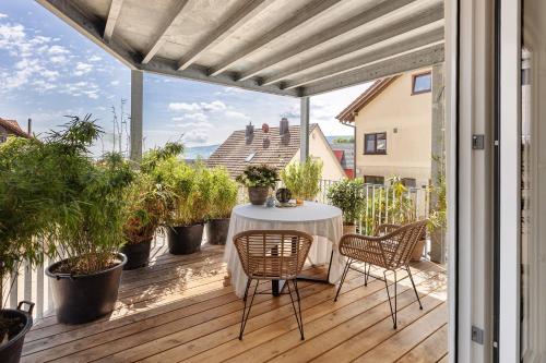 a patio with a table and chairs on a deck at Seeapartment Höri in Gaienhofen