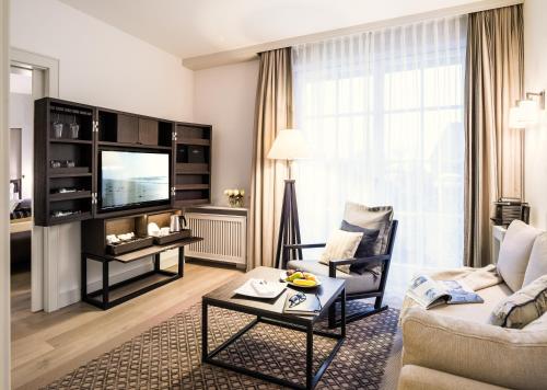 a living room with a couch and a tv at Severin's Resort & Spa in Keitum
