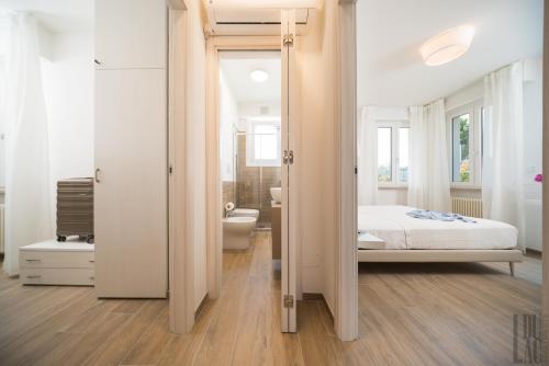 een witte slaapkamer met een bed en een badkamer bij Belle Maison - Du Lac Apartments in Sirmione