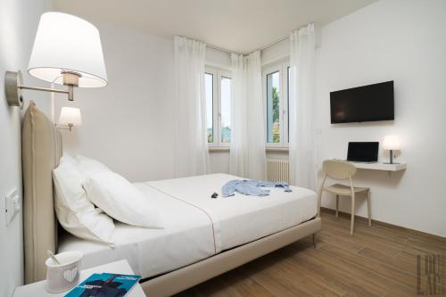 een witte slaapkamer met een bed en een bureau bij Belle Maison - Du Lac Apartments in Sirmione