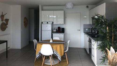une cuisine avec une table et des chaises dans une cuisine dans l'établissement Appartement centre ville avec vue sur l'Adour, à Bayonne