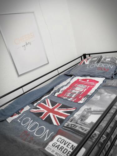ein Bett mit Plakaten und Fotografien darüber in der Unterkunft Logement privé dans une Villa avec piscine in Dalhunden