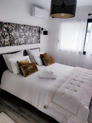 une chambre avec un grand lit blanc avec deux serviettes dans l'établissement Joli havre de paix, à Prades-le-Lez