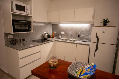 a kitchen with white cabinets and a wooden table at Viví Potrerillos in Potrerillos