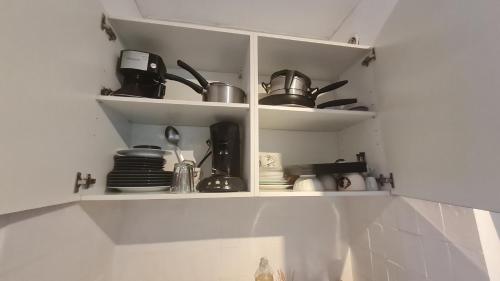 - une étagère de cuisine avec casseroles et poêles dans l'établissement Petit studio promenade des Anglais, à Nice
