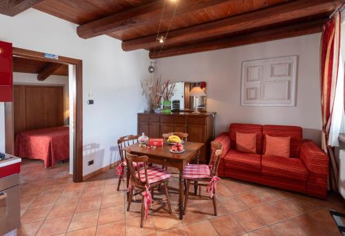 a living room with a table and a red couch at Cascina Giardini in Alba