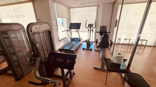 una palestra con tapis roulant e attrezzature per il fitness in una sala di Apartamento Pudrimel a San Blas