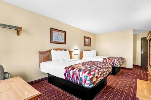 a hotel room with two beds and a table at Americas Best Value Inn Decatur in Decatur