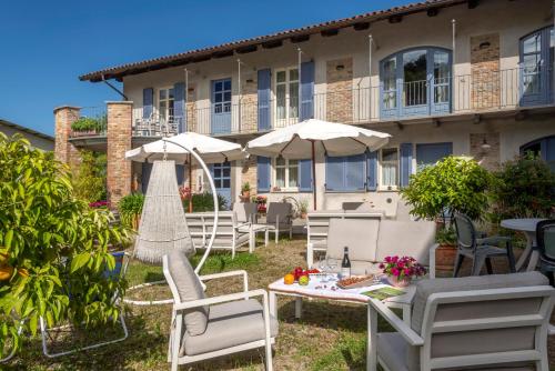 a patio with chairs and tables and umbrellas at Cascina Giardini in Alba