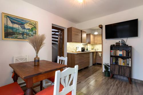 Una cocina y un comedor con una mesa y un televisor. en Birs Kunyhó, en Parád