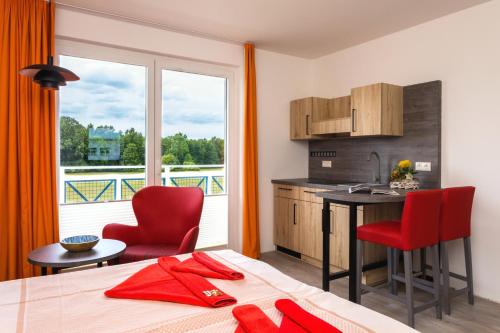 a room with a bed and a kitchen with a balcony at Hotel & Restaurant Hanse Kogge in Ostseebad Koserow