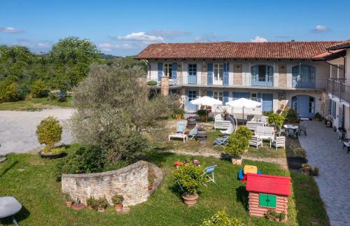 a building with a yard with chairs and tables at Cascina Giardini in Alba