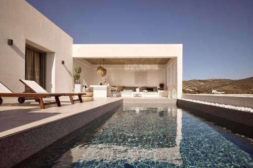 a house with a swimming pool and a living room at Thea Luxury Villas Ios in Plakotos