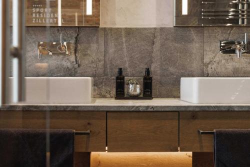 a bathroom with two sinks and two bottles at Sportresidenz Zillertal - 4 Sterne Superior in Uderns