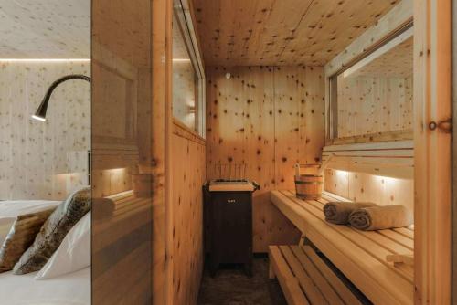 a room with wooden walls and a bed and a room with a bed at Sportresidenz Zillertal - 4 Sterne Superior in Uderns