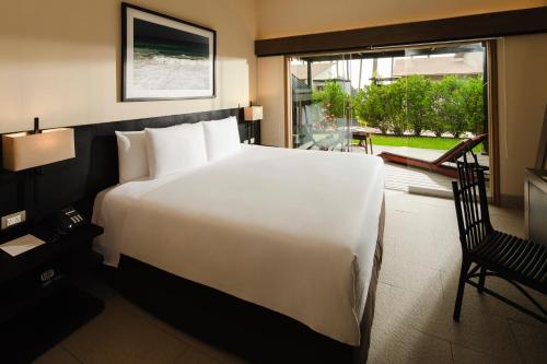 a large white bed in a room with a window at Arennas Mancora in Máncora
