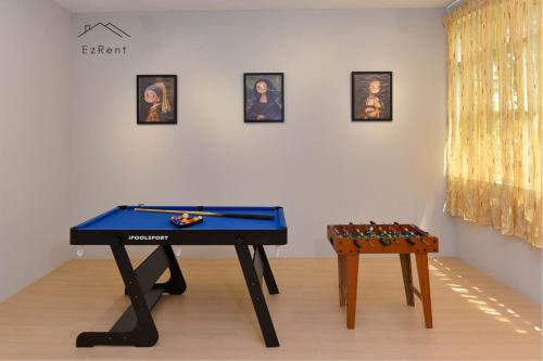 a ping pong table in a room with two games at Cozy Muji Studio Homestay near Taiping Lake Garden in Taiping