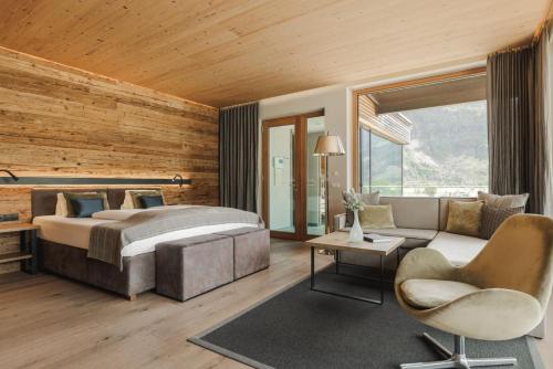 1 dormitorio con 1 cama, 1 sofá y 1 silla en Sportresidenz Zillertal - 4 Sterne Superior en Uderns