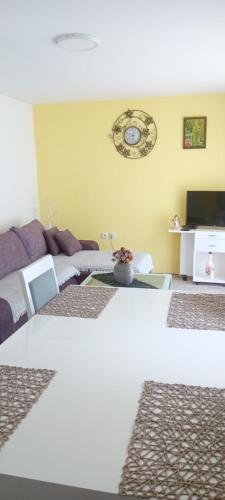 a room with a table and a clock on the wall at Apartmani Romansa Perucac in Perućac