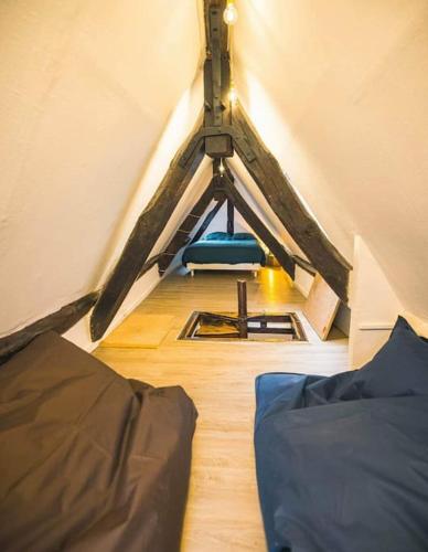 Cette chambre mansardée comprend deux lits et une chaise. dans l'établissement La Bonbonnière de Saint Maclou, à Rouen
