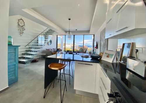 une cuisine avec un comptoir et des tabourets dans une pièce dans l'établissement Premium HOME: Bungalow-Apartment mit Rooftop nahe Golfclub & SPA, à Ayios Yeoryios