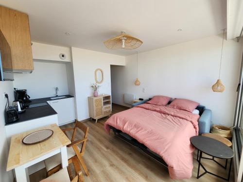 une chambre avec un lit et une table et une cuisine dans l'établissement Studio Face Mer, à Saint-Jean-de-Monts