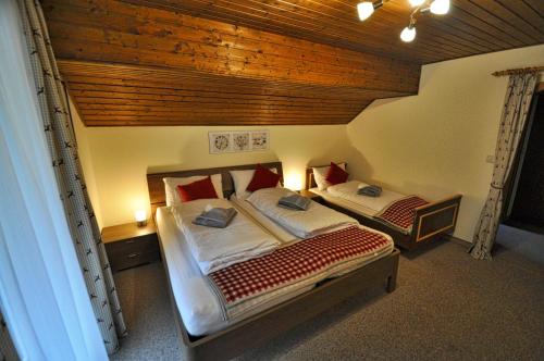 2 Betten in einem Schlafzimmer mit Holzdecke in der Unterkunft Gasthaus Chalet Mur in Sankt Michael im Lungau
