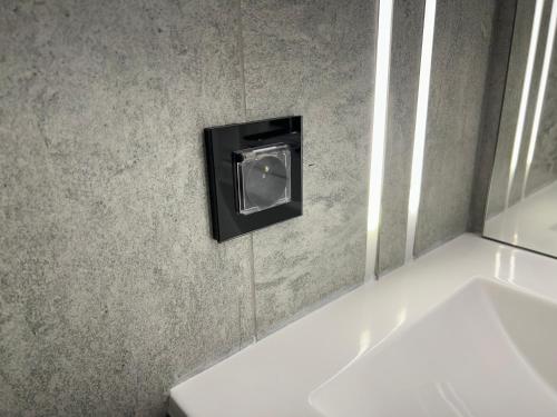 a bathroom with a soap dispenser on the wall at ALEM Hotel in Almaty
