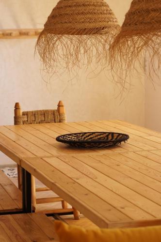 un tavolo di legno con un piatto sopra di The Line Up a Mirleft
