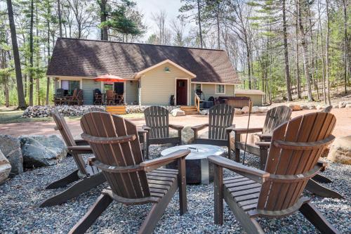 a group of chairs and a table in front of a house at Northwood Tours Escape Hot Tub and Lake Access! in Minocqua