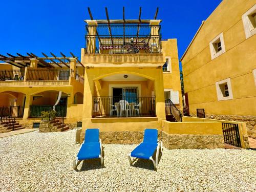 twee blauwe stoelen voor een gebouw bij Casa Dream Beach in Cuevas del Almanzora