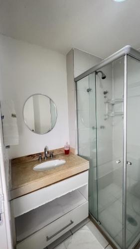 a bathroom with a sink and a glass shower at Beach Living 1111 in Aquiraz