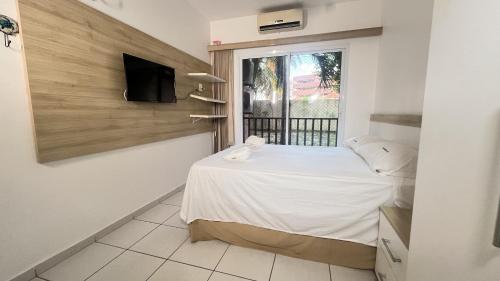 アキラスにあるBeach Living 1111のベッドルーム(窓、ベッド、テレビ付)