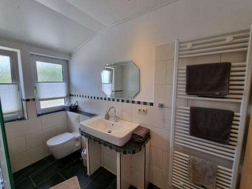 a white bathroom with a sink and a toilet at Heeser Hof - Urlaub im Grünen in Weeze