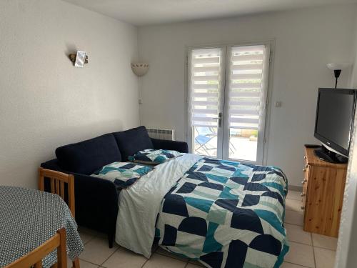 a bedroom with a bed and a flat screen tv at les fermettes de la plage in Saint-Nic