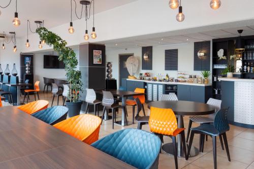 un restaurant vide avec des tables et des chaises dans l'établissement Kyriad Belfort Centre Gare, à Belfort