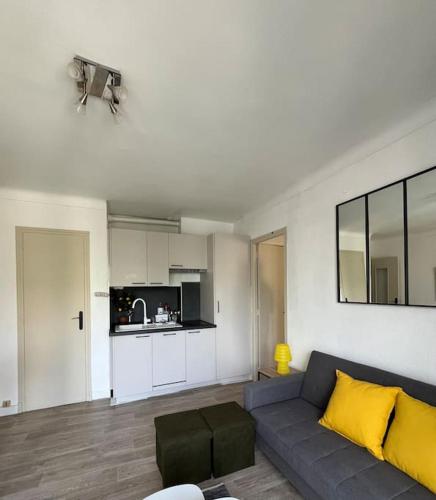 un salon avec un canapé et une cuisine dans l'établissement Le Sailor - Appartement à la plage, à Canet