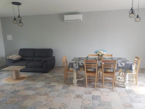 un salon avec une table et un canapé dans l'établissement Appartement spacieux et confortable à Clermont-Dessous, terrasse, à Clermont-Dessous