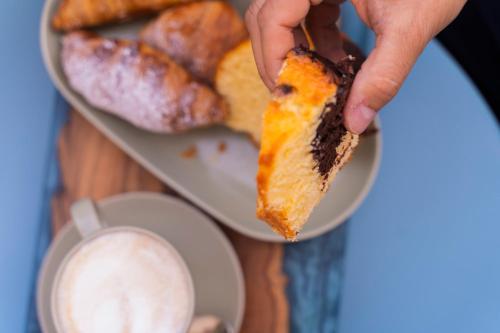 a person holding a piece of bread and a plate of pastries at Greenlove in Agerola