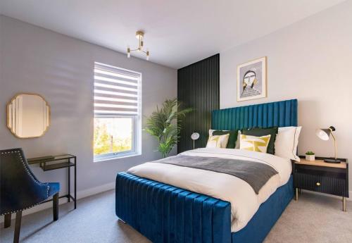 a bedroom with a large blue bed and a chair at Glasswing Stays Margaret st, central Sheffield in Sheffield