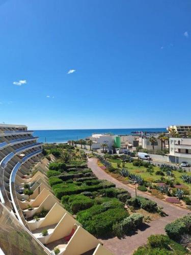une vue sur la plage depuis le balcon d'un immeuble dans l'établissement Studio Héliopolis L1 -Vue mer - 4 personnes, au Cap d'Agde