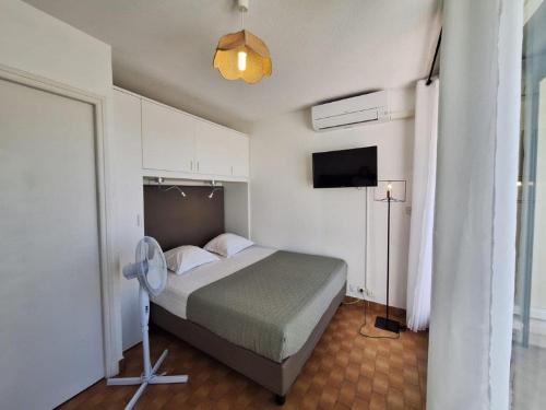 - une chambre avec un lit, un ventilateur et une télévision dans l'établissement Studio Héliopolis L1 -Vue mer - 4 personnes, au Cap d'Agde