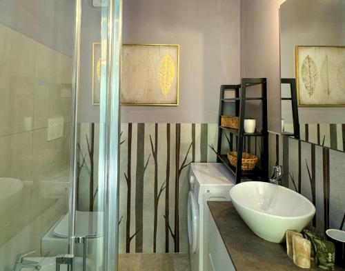a bathroom with a sink and a glass shower at SANS SOUCIS - Design Apartment - Near Nettuno Center, Beach & Station in Nettuno