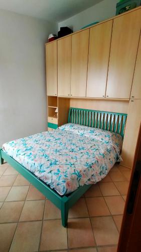 a bed in a room with wooden cabinets at Villetta Mari Pintau in Geremèas