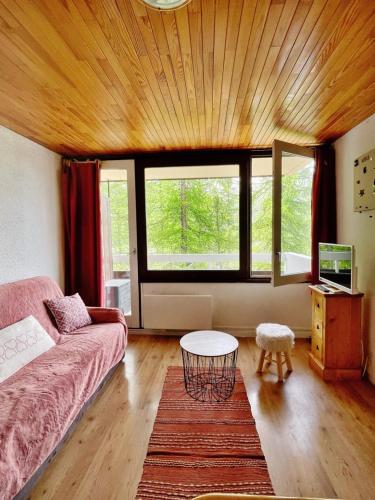 un salon avec un canapé et une table dans l'établissement Studio au pied des pistes avec terrasse, à Vars