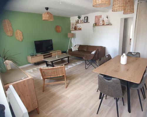 una sala de estar con una mesa y un sofá en "Carpe diem" Charmante maison CDG-RER B-Parc des expos de Villepinte-Astérix-Stade de france, en Villeneuve-sous-Dammartin
